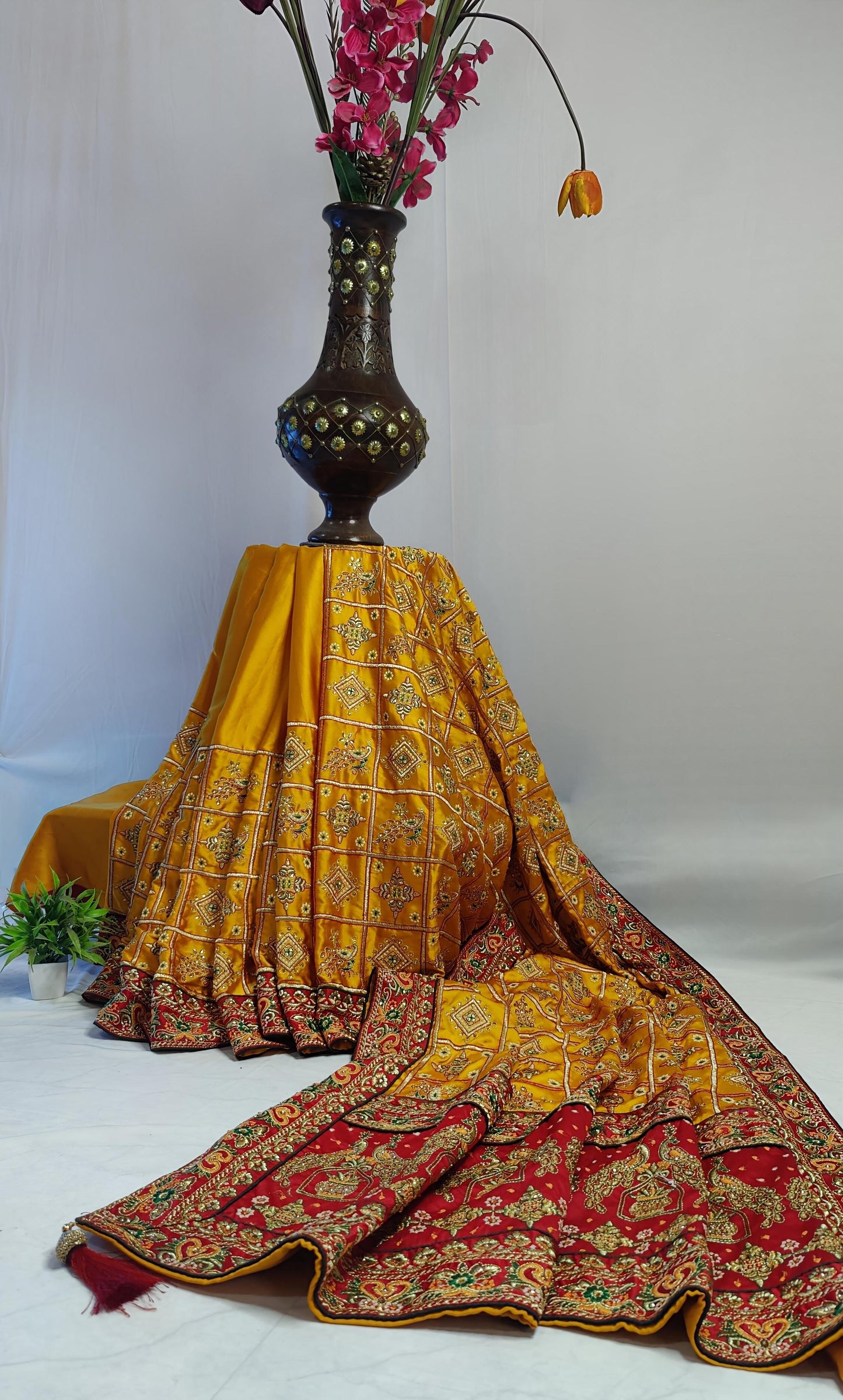 YELLOW SATIN SILK SAREE WITH HEAVY RED BORDER.