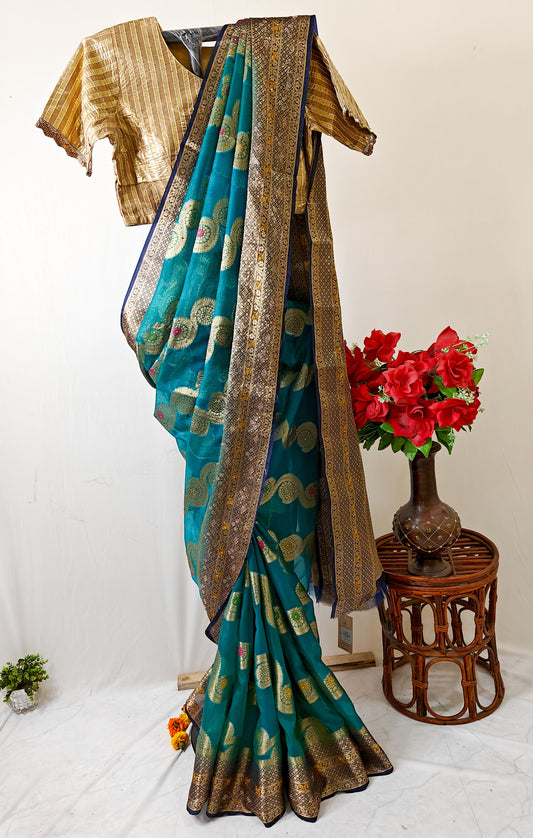 TEAL BLUE ORGANZA SILK SAREE WITH INTRICATE DARK BLUE AND GOLDEN ZARI WEAVING.