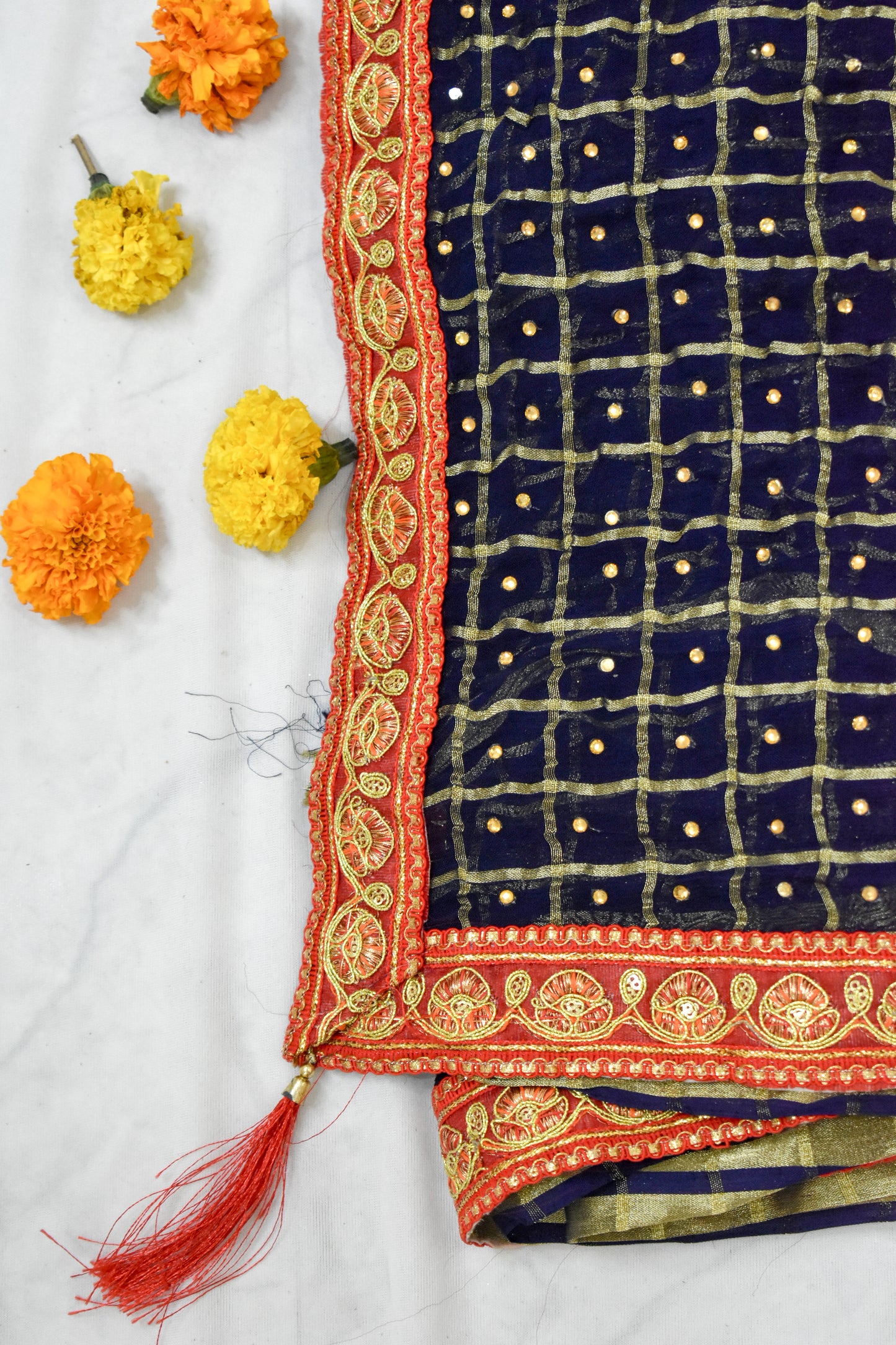 NAVY BLUE CRUSHED GEORGETTE BANDHANI SAREE WITH RED ZARI BORDER.