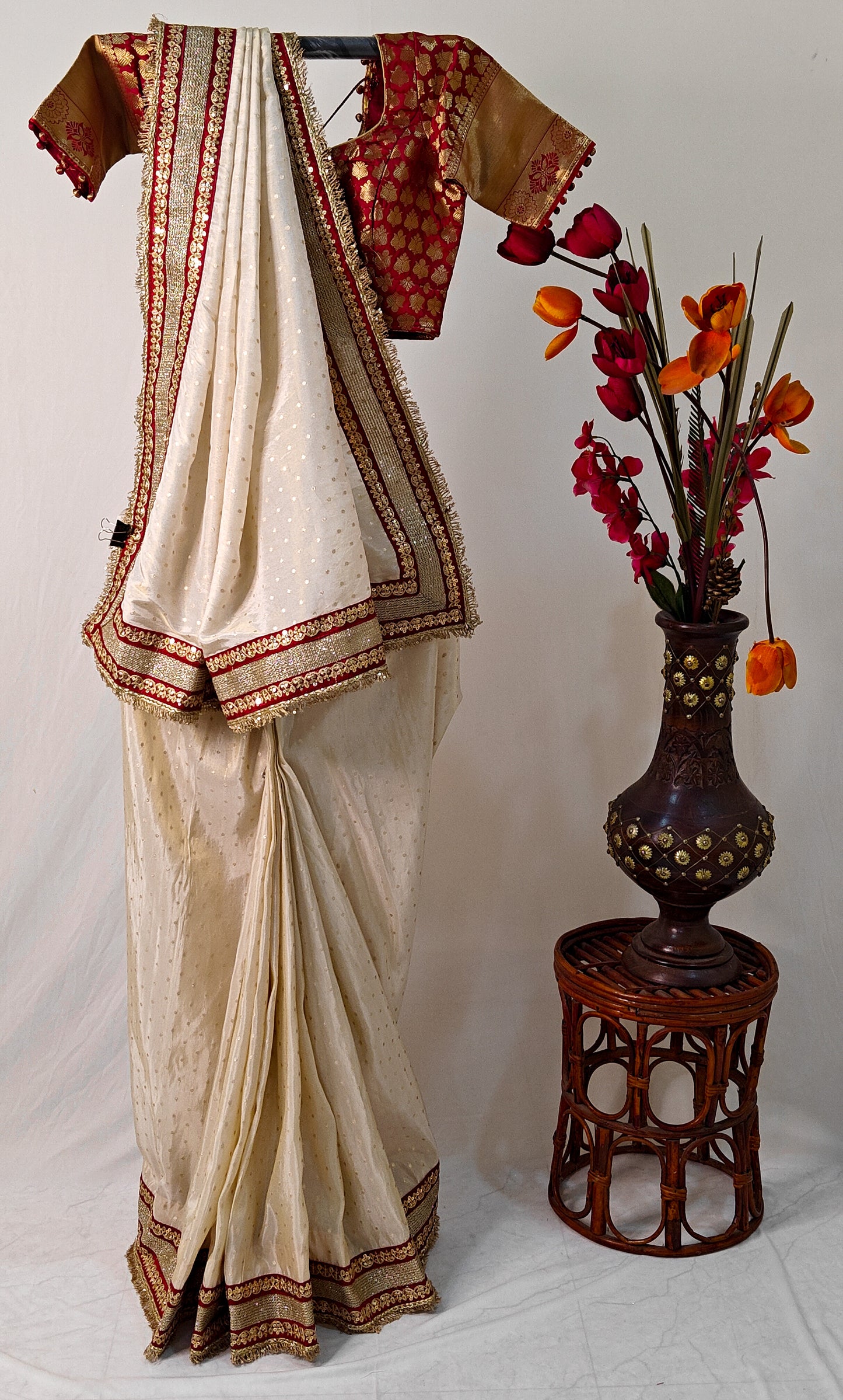 IVORY TISSUE SAREE WITH HEAVY MAROON ZARI BORDER AND FRINGE DETAILING.