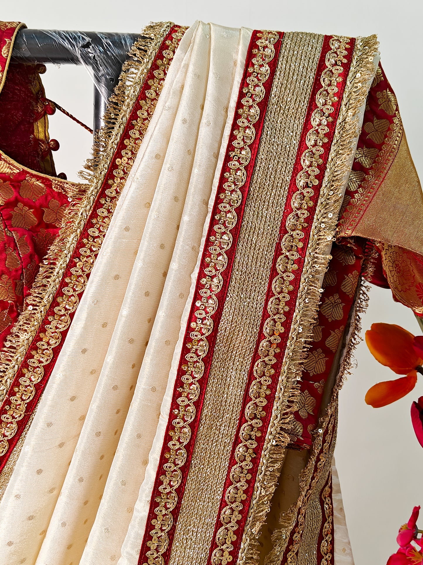 IVORY TISSUE SAREE WITH HEAVY MAROON ZARI BORDER AND FRINGE DETAILING.