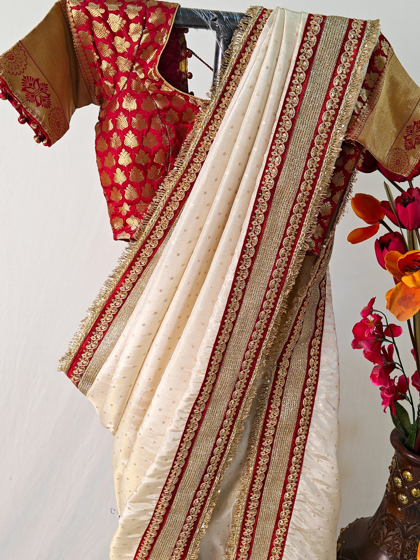 IVORY TISSUE SAREE WITH HEAVY MAROON ZARI BORDER AND FRINGE DETAILING.