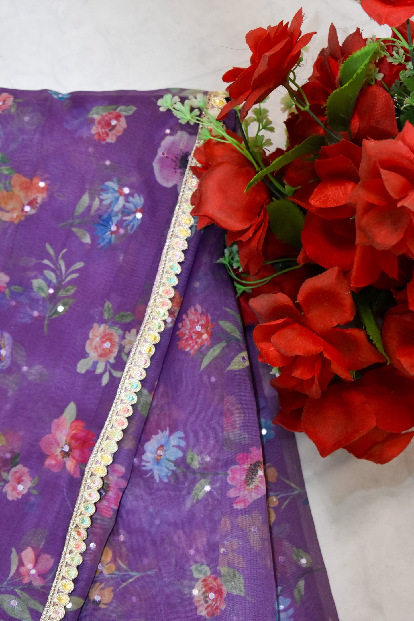 PURPLE ORGANZA FLORAL PRINT SAREE WITH MULTICOLOUR SEQUIN BORDER.