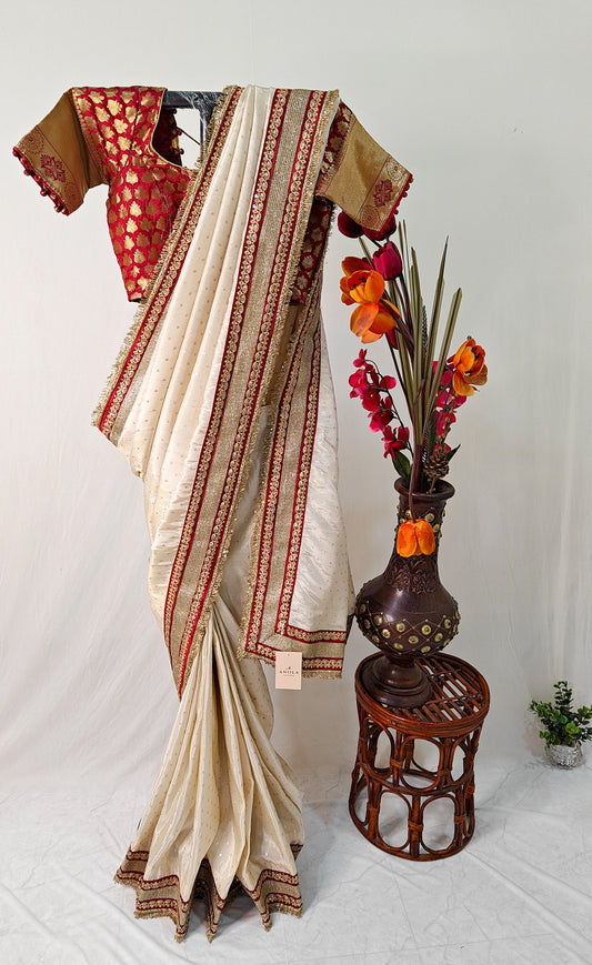 IVORY TISSUE SAREE WITH HEAVY MAROON ZARI BORDER AND FRINGE DETAILING.